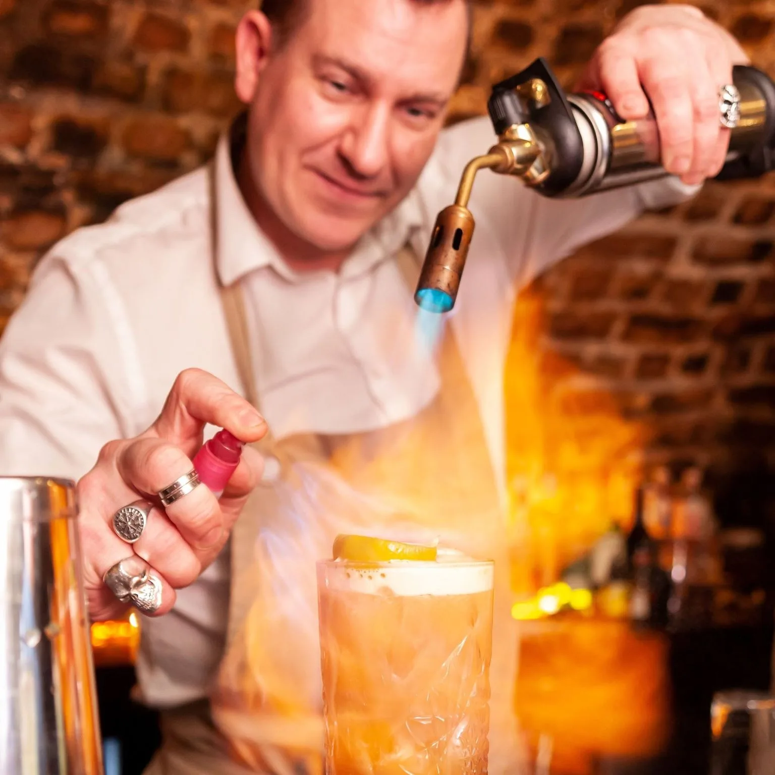 Bartender using a blow torch to finish a cocktail at The Old Workshop, Aberdeen