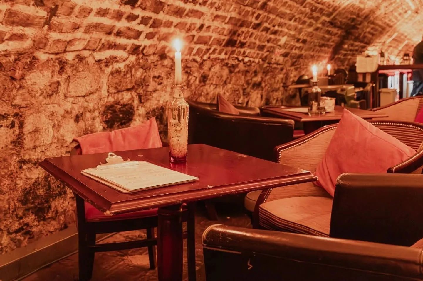 Cosy table and cushioned seating in the brick tunnel at The Old Workshop, Aberdeen