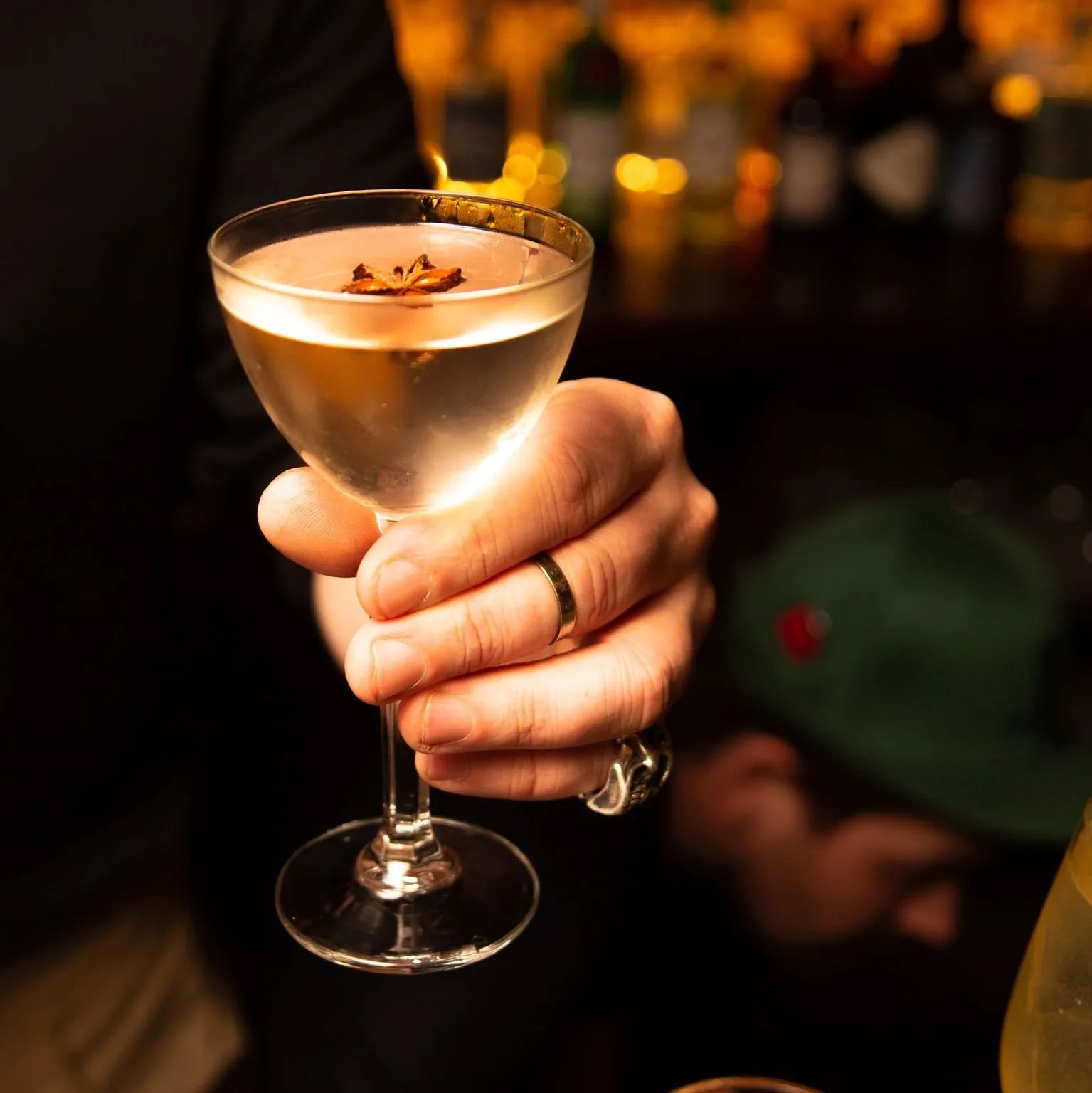 Hand holding a garnished coupe cocktail at The Old Workshop bar, Aberdeen
